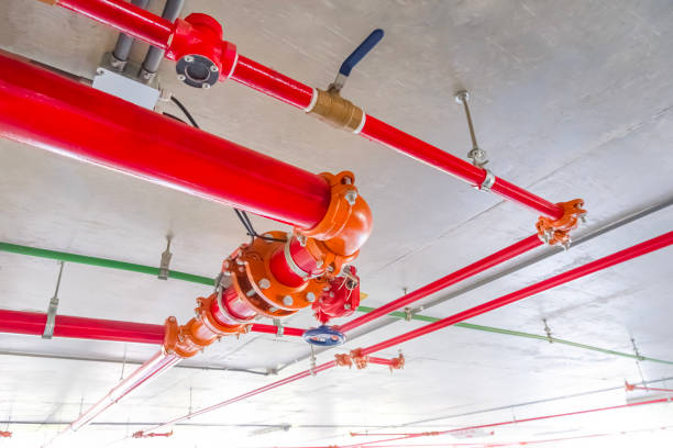 istock Red fire protective water pipeline system on concrete ceiling inside of parking garage building 2166790892