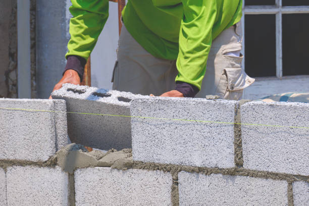 istock Bricklayer making concrete block wall inside of house construction site 2166790986