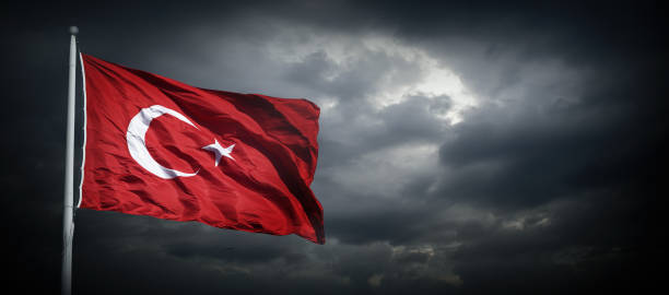 istock The Turkish flag waving among dark clouds. 2166791284