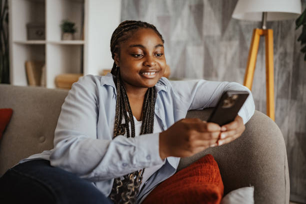 istock Woman smiling while looking at smartphone indoors. 2166791513