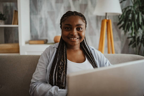 istock Woman smiling while sitting with a laptop at home 2166791762
