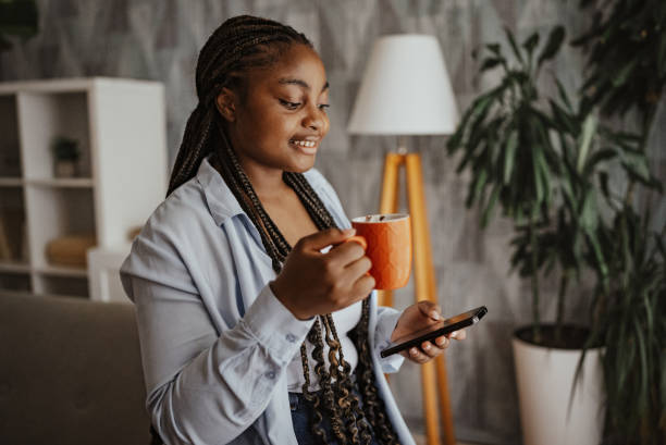 istock Woman with coffee mug and phone surrounded by plants 2166793480
