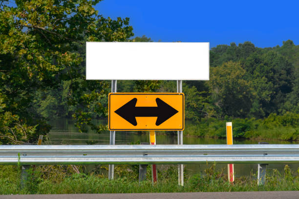 Horizontal shot of two way arrow road sign with blank signage above with copy space.