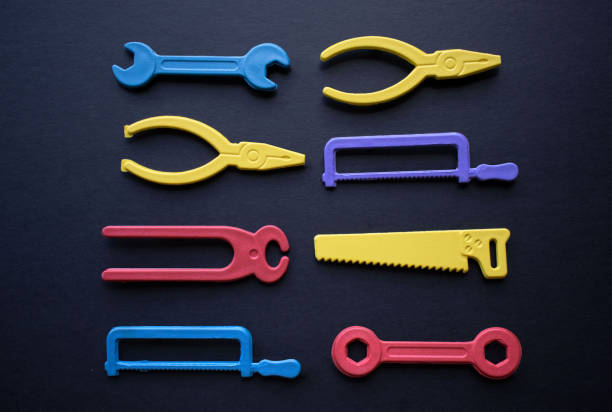 Set of hand tools made of small colorful plastic molds on dark background, work and order concept
