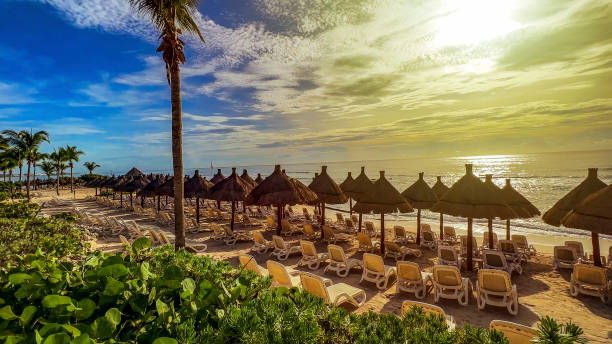istock Tropical scenery with deck chairs and thatched umbrellas on a beach under a blue sky. 2166797173