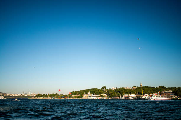 A picturesque view of the Bosphorus in Istanbul, featuring a passenger ferry cruising through the water, with the city's skyline and iconic landmarks in the background.
