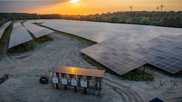 istock Industrial solar power station, currently under construction, showcasing solar modules and the array of white combiner boxes with power cables for connection to solar energy system grid. 2166798879