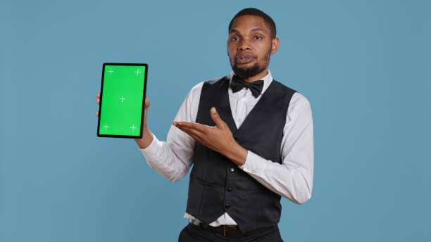istock Bellman hotelier showing a tablet with green screen display in studio 2166799281