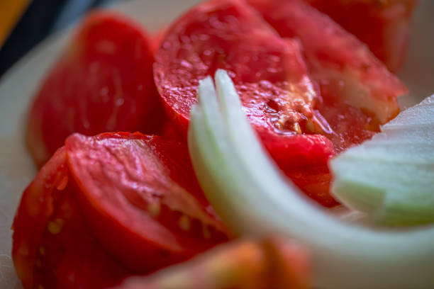 A macro photo capturing the fresh, vibrant layers of sliced onion and juicy tomato in a simple yet appetizing salad.