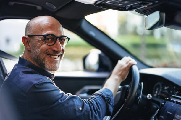 istock Smiling Businessman Driving Car in Urban Setting 2166802696