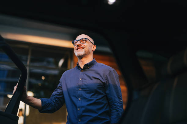 istock Businessman With Glasses Smiling While Exiting a Car 2166802699