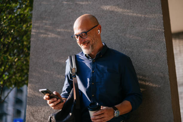 istock Businessman Smiling While Using Smartphone Outdoors in the City 2166802728