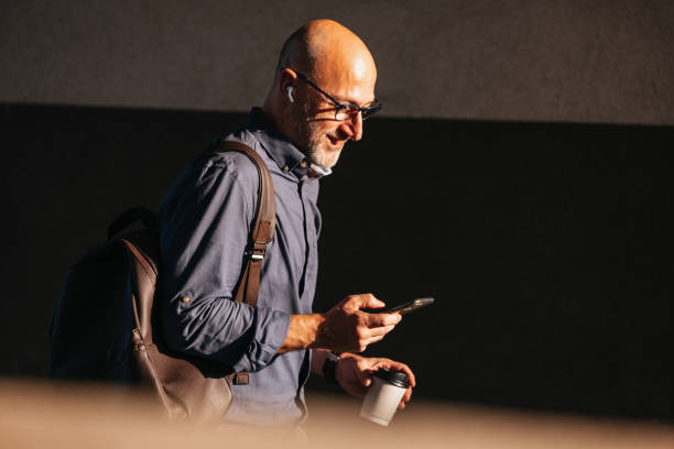 istock Businessman Walking with Smartphone and Coffee in Urban Setting 2166802754