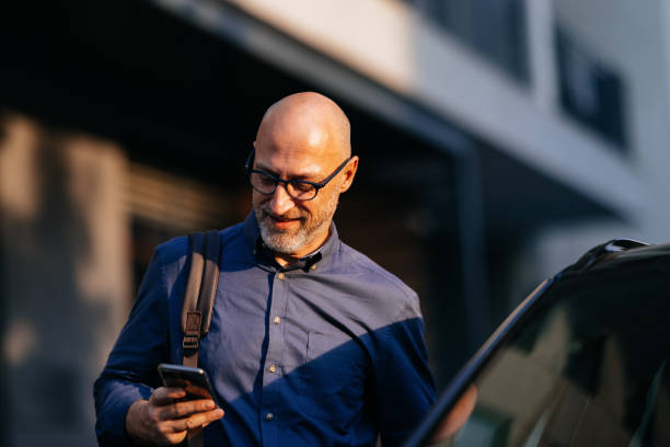 Businessman Walking in City with Mobile Phone and Backpack
