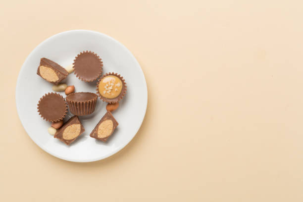 istock Delicious peanut butter cups with nuts on color background, top view 2166804469