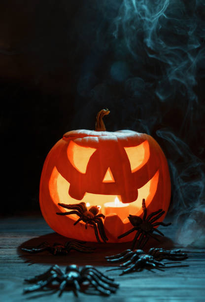 istock Halloween pumpkins festive background. Moonlight and candlelight. Jack-o-lantern halloween mystic background with mist, spiders, bat and fog, bats 2166806752
