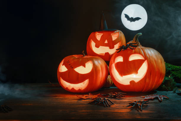 istock Halloween pumpkins festive background. Moonlight and candlelight. Jack-o-lantern halloween spooky background, bats 2166807170