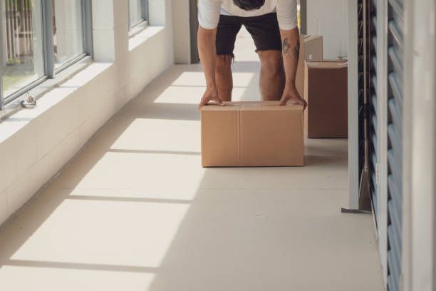 istock A man is holding a cardboard box in a hallway 2166808655