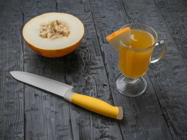 istock Fresh Melon Juice with Half Melon and Knife on Rustic Wooden Table 2166821143