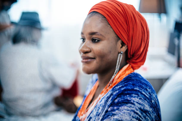 Beautiful African woman wearing earrings in front of mirror