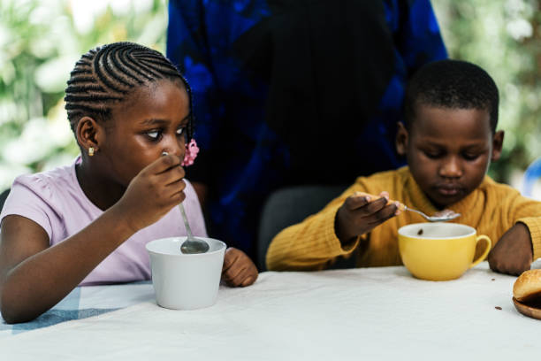 Black boy black girl eating cereals for breakfast at home