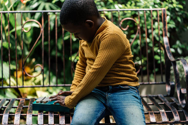 Close up of Black boy playing Kalimba in backyard
