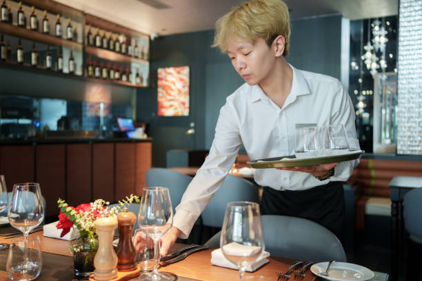 istock Restaurant waiter placing wine glasses 2166824404