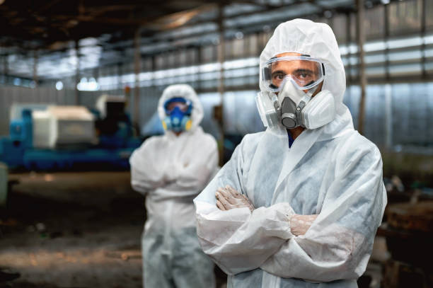 istock Two men in white protective gear stand in a factory 2166826778