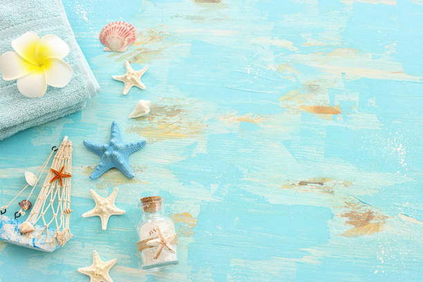 nautical concept with starfish and seashells over old wooden blue background