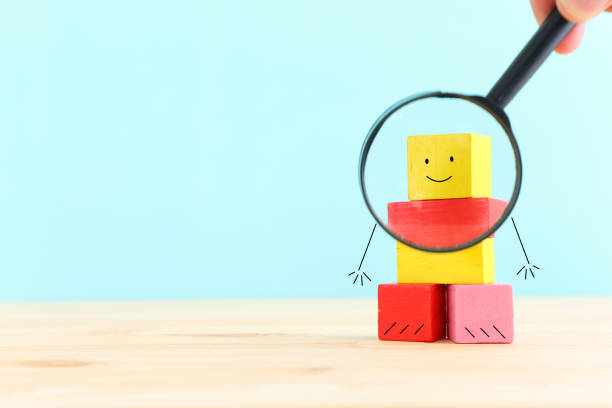 istock Concept image of satisfaction level. wooden cube with emotions and magnifying glass 2166830362