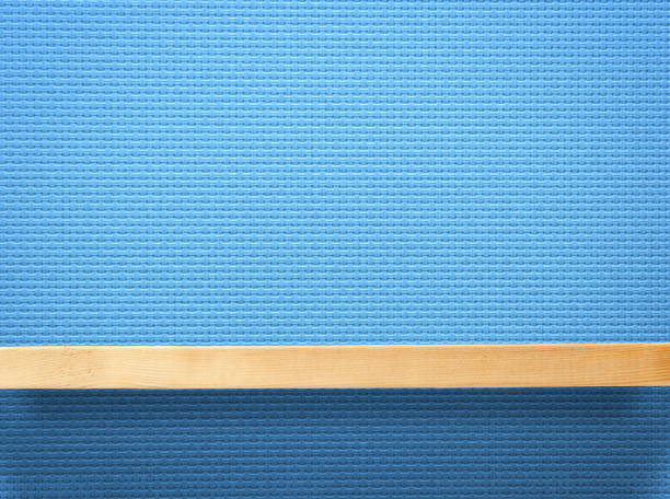 Close-up of empty wooden shelf against blue wall.