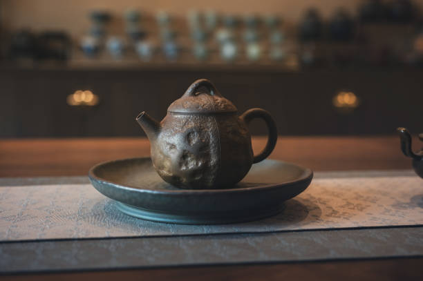 istock Rustic brown teapot on a ceramic plate with intricate surface texture. 2166834736