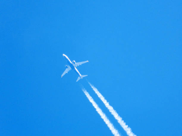 istock aircraft leaving white tracks in blue sky 2166835137