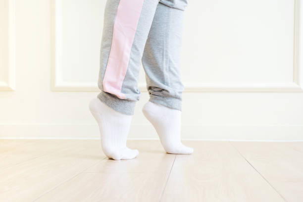 istock Legs doing exercises lifting on toes close-up, home workout concept. 2166836097
