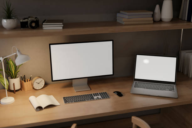istock A home workspace at night features a computer and a laptop mockups on a wooden table. 2166836293