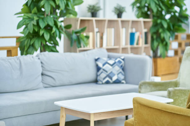 istock Modern interior design, in a spacious room, next to a table with flowers on a light background. A bright, spacious room with a comfortable sofa and plants with space to copy 2166837183