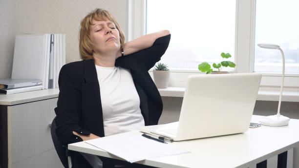 istock A female office worker stretches her stiff neck 2166837821