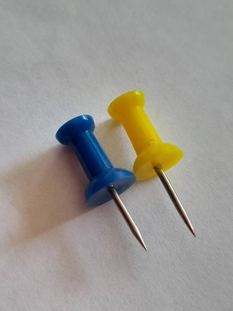 istock One yellow and one blue paper clip pin 2166838877