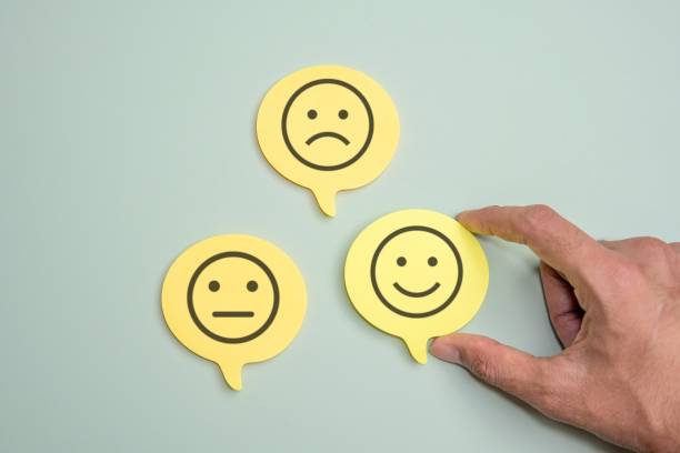 istock A hand hovers over a yellow speech bubble with a smiling face icon. 2166839714