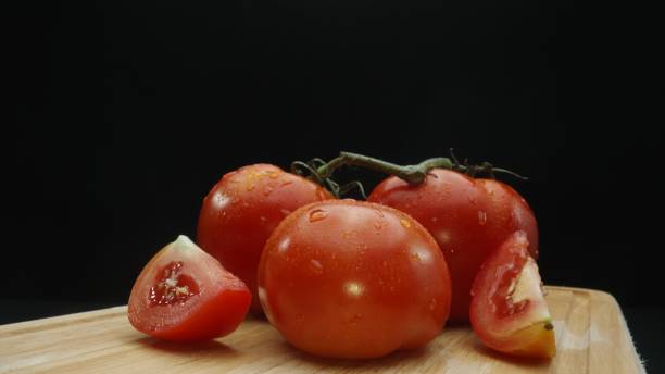 istock Macrography, slices of tomato placed on board with black background. Comestible. 2166840638