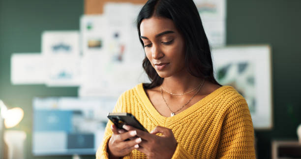 istock Indian woman, home and serious with smartphone in study room for elearning group and announcement. Female person, university learner and browsing internet with social media interaction and posts 2166841968