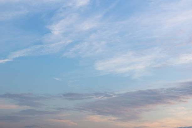 Vast evening sky with gentle blue and white tones, subtly accented by light pink clouds
