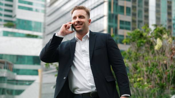 istock Businessman standing at rooftop while talking with team by using phone. Urbane 2166844902