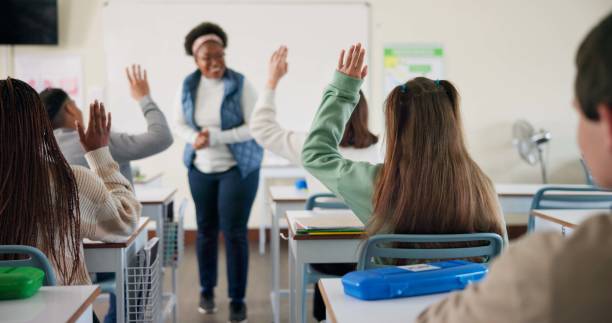 istock Hands, question and students in classroom, education and preparing for exam with teacher, learning and college. Answer, person and feedback of professor, knowledge and listening in university 2166845666