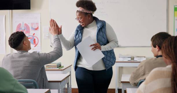 istock Teacher, high five and student in college, education and preparing for exam with smile, learning or classroom. Professor, person and hand for answer, knowledge or feedback for listening or university 2166845692