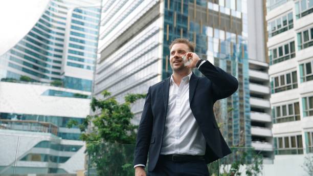 istock Businessman talking to team by using phone while standing at skyscraper. Urbane. 2166845880