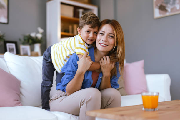 istock Cheerful mother with son on her back, cozy home 2166846747