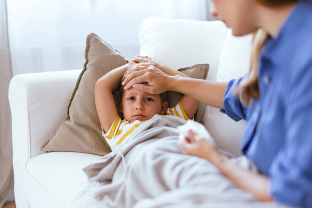 istock Loving mother tending to sick child on white sofa. 2166847060