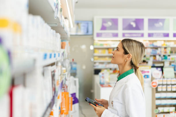 istock Young woman pharmacist at her workplace using mobile phone 2166849278