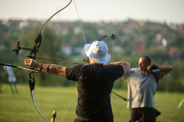 istock Teenage boy and a man practicing archery with recurve and compound bow on the training field 2166849987
